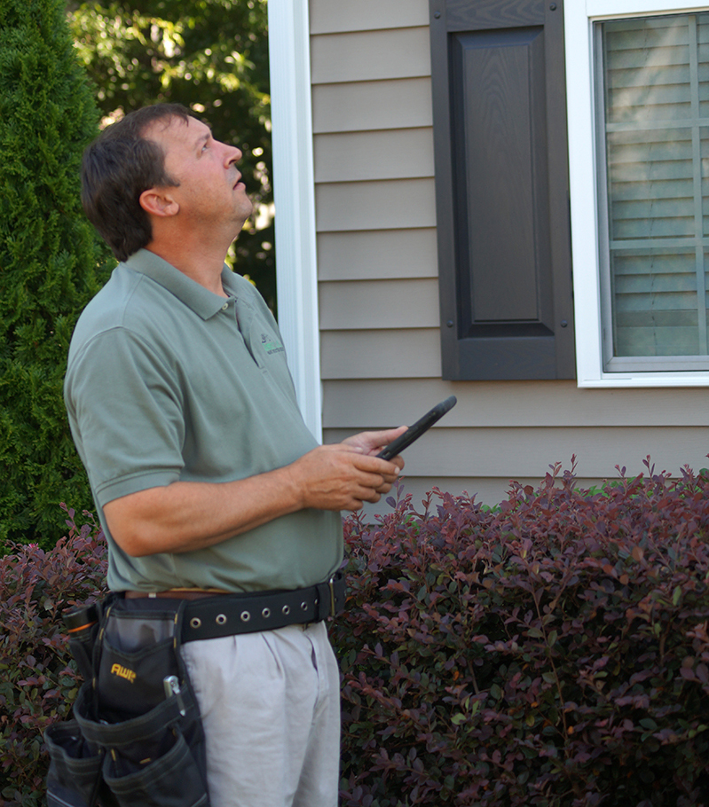 Home inspector Mitch Wyatt looking up at the exterior of a home